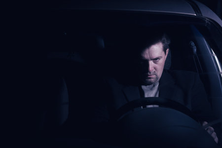 Businessman driving at night in the city