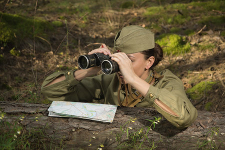 Woman in uniform of the Red Army of the Second World War. She watches through binoculars and scouts.の写真素材