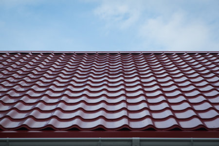 Construction of the roof of the house. Metal tiles