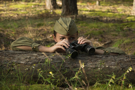 Woman in uniform of the Red Army of the Second World War. She watches through binoculars and scouts.の写真素材