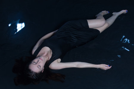 Young woman lying in a water in a poetic representation.の写真素材