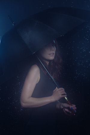 Young happy girl under an umbrella in the rain
の写真素材