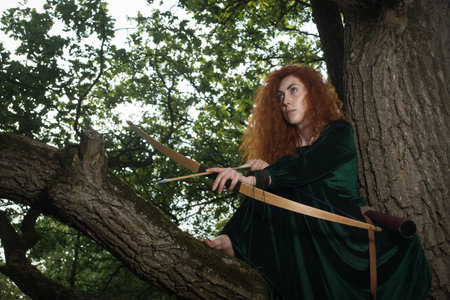 Red haired girl shoots from the bow. Fantasy conceptの写真素材