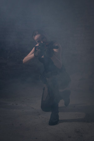 A girl in uniform with a submachine gun fires の写真素材