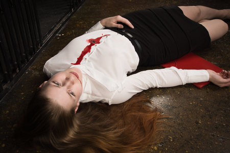 Crime scene. Business woman shot in the chest in old elevatorの写真素材