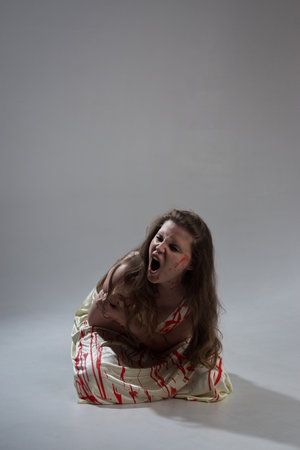Horror film. A girl in a bloody dress screams in pain
の写真素材