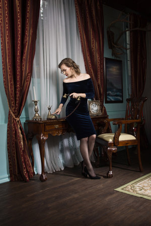 Beautiful attractive woman in the vintage interior speaks by phoneの写真素材