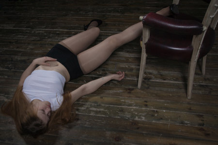 Thriller film. Lifeless unconscious woman lying on a factory floorの写真素材