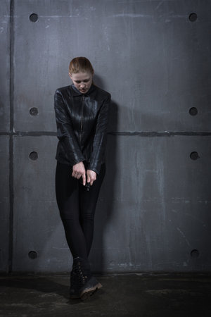 Hit woman. Biker girl in a black suit with gun in handの写真素材