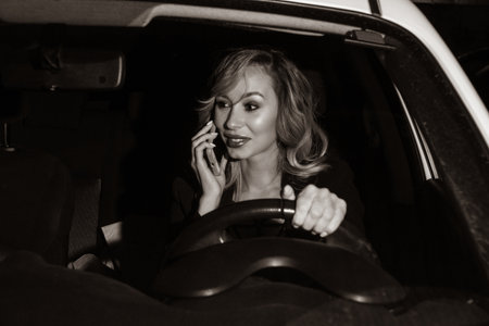Noir film. Young confident businesswoman driving car. City concept