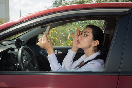 Young confident businesswoman driving car. City concept
