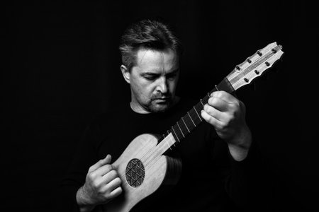 Adult man playing renaissance guitar