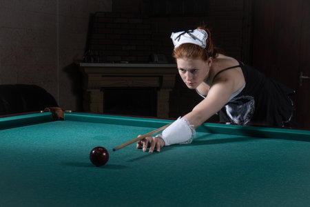 Young sexy chambermaid plays billiard. Pin up style.の写真素材