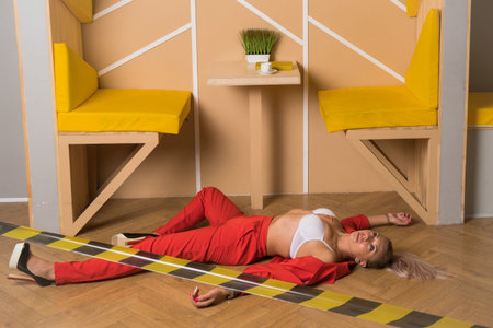 Crime scene imitation. Dead woman lying on a floor. She was shot in the chestの写真素材