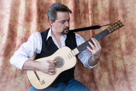 Adult man playing baroque guitarの写真素材