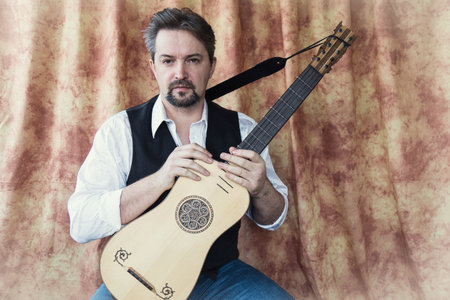 Adult man playing baroque guitarの写真素材