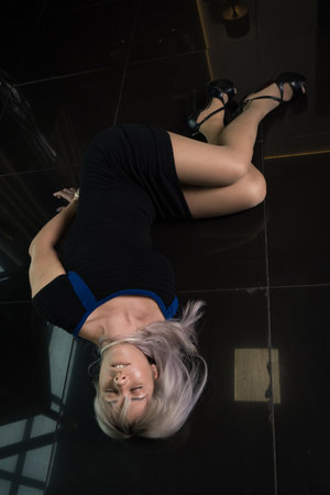 Crime scene simulation: dead girl with hands tied lying on the floor. She was strangled with a rope.の写真素材