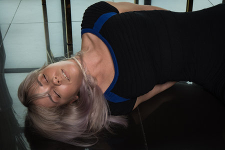 Crime scene simulation: dead girl with hands tied lying on the floor. She was strangled with a rope.の写真素材