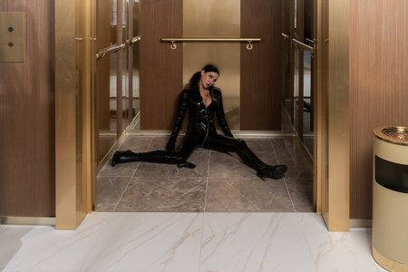 Hit woman. Woman in a latex suit killed in gunfire shot in the chestの写真素材