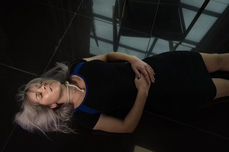 Crime scene simulation: dead girl with hands tied lying on the floor. She was strangled with a rope.の写真素材