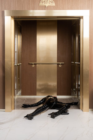 Hit woman. Woman in a latex suit killed in gunfire shot in the chestの写真素材