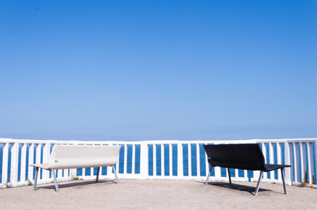 Pair of black and white benches overlooking the Cantabrian Sea in the village of Candas, Asturias, Spain.の写真素材