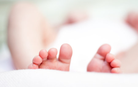 feet and fingers of a newborn baby, with white background out of focus.の写真素材