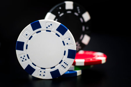 set of poker chips of different colors on a black background.の写真素材