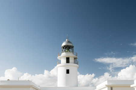 Traditional white light house in a sunny day in Cap Cavaller?a, Menorca, Balearic Islands, Spain.の写真素材
