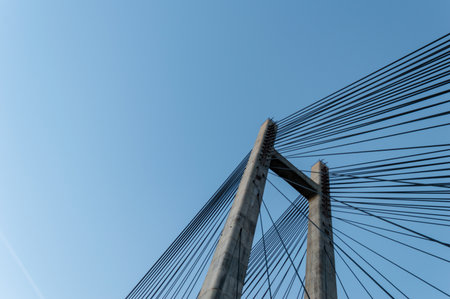 Modern cement bridge pylon structure over clear blue sky.の写真素材