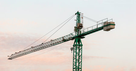 Silhouette of Tower construction crane and the building against a beautiful sky at sunset backgroundの写真素材