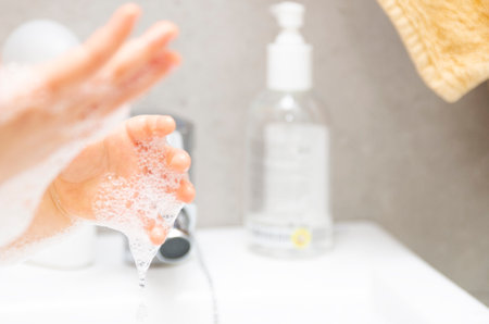 Hygiene concept. Child Washing their Hands with Soap and Water in the bathroomの写真素材