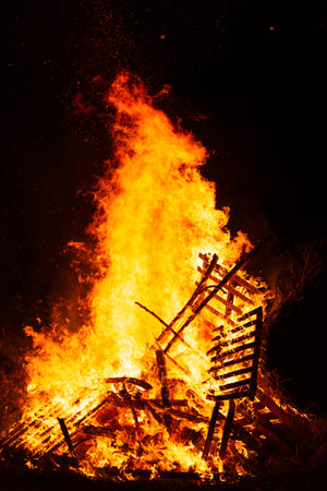 Burning woods with fire sparks, flame and smoke at night fireplace.の写真素材