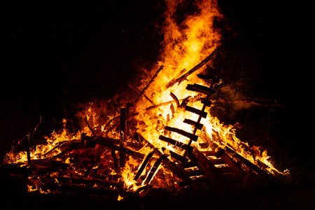 Burning woods with fire sparks, flame and smoke at night fireplace.の写真素材