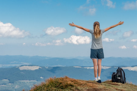 athletic girl climbed on top of the mountain and enjoys the freedom of hands openingの写真素材
