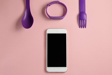 flat lay fitness set with phone, tracker, spoon and forkの写真素材