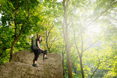 Girl tourist with a backpack near the rockの写真素材