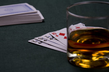 Glass with cognac and playing cards in a casino