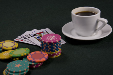 Cup of coffee and chips for a game in a casinoのeditorial素材