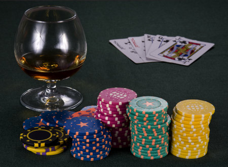 Glass with cognac and chips for a game in a casinoのeditorial素材