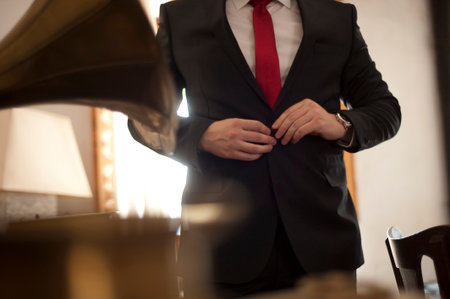 The groom,  man clasps a button at a jacketの写真素材