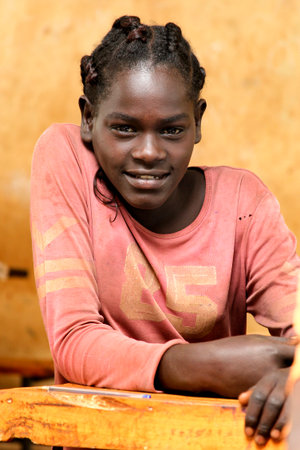 JINKA,ETHIOPIA - NOVEMBER 25, 2011: Portrait of the African schoolgirl sitting at a school desk during a lesson on November 21, 2011 in Jinka, Ethiopia.のeditorial素材