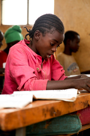 JINKA,ETHIOPIA - NOVEMBER 25, 2011: Portrait of the African schoolgirl sitting at a school desk during a lesson on November 21, 2011 in Jinka, Ethiopia.のeditorial素材