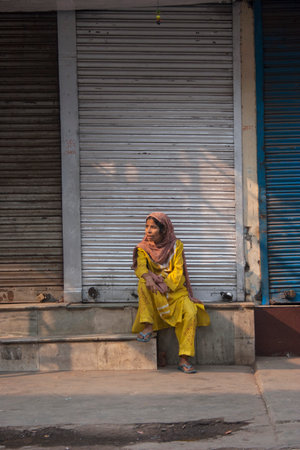 NEW DELHI, INDIA - October 30, 2006: Unidentified Indian woman sitting on the streets of New Delhi, India.のeditorial素材