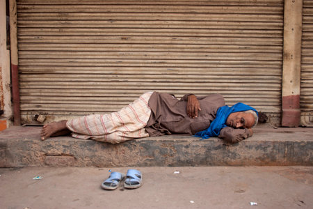 NEW DELHI, INDIA - October 30, 2006: Unidentified Indian homeless man sleeps on the streets of New Delhi, India.のeditorial素材