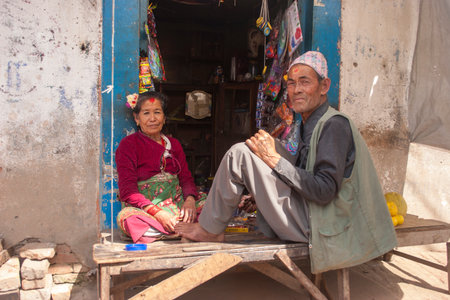 KATHMANDU, NEPAL - NOVEMBER 06, 2006: Old woman and man sitting intertwined their shop on Kathmandu Valley, Nepal.のeditorial素材