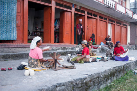 Pokhara, Nepal - NOVEMBER 03, 2006. The unidentified woman spinning wool on the street Pokhara, Nepal.のeditorial素材