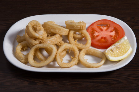 Calamares a la romana spanish dish served with lemon on the side, or as a sandwich.の写真素材