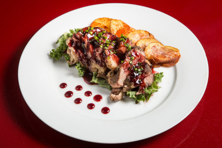 Beef with sauce ande chips on the white dinner plateの写真素材