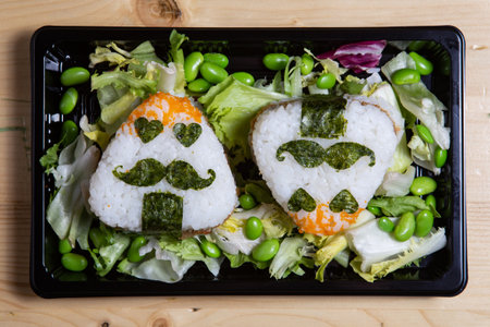 Japanese rice balls onigiri with chicken and saladの写真素材